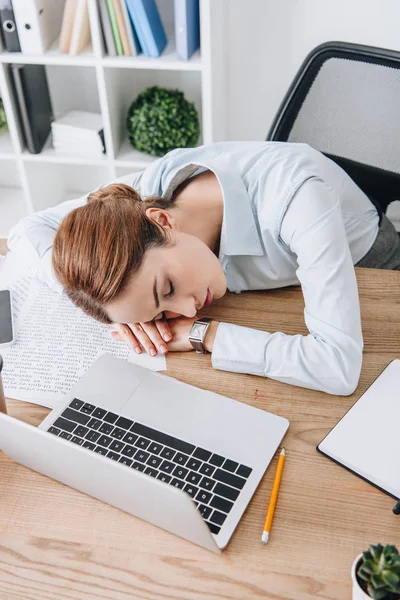 Vue grand angle de femme d'affaires adulte dormant sur le lieu de travail dans un bureau moderne — Photo de stock