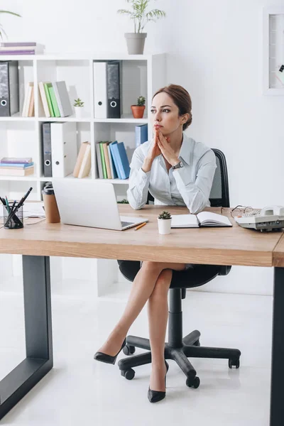 Donna d'affari fiduciosa premurosa seduta sul posto di lavoro in ufficio moderno — Foto stock