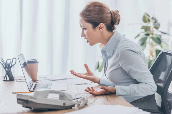 Donna d'affari adulta pazza che guarda lo schermo di computer portatile a ufficio — Foto stock