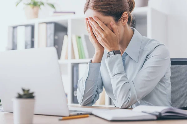 Femme d'affaires adulte stressée couvrant le visage avec les mains au bureau — Photo de stock