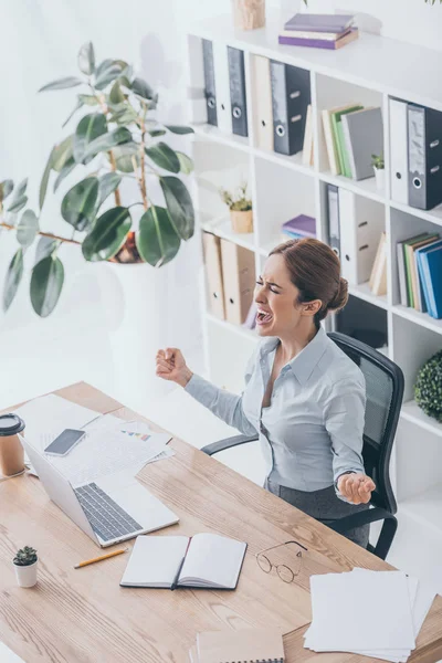 High angle view of stressed adult businesswoman screaming at workplace — Stock Photo
