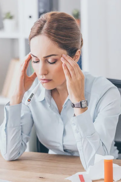 Adult sick businesswoman with headache sitting at workplace with closed eyes — Stock Photo