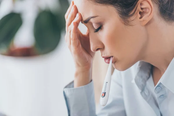 Close-up shot of suffering sick businesswoman with electric thermometer in mouth — Stock Photo