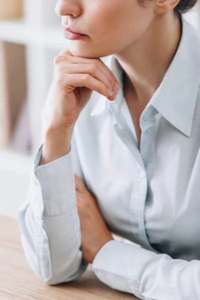 Cropped shot of adult businesswoman touching chin with hand at office — Stock Photo