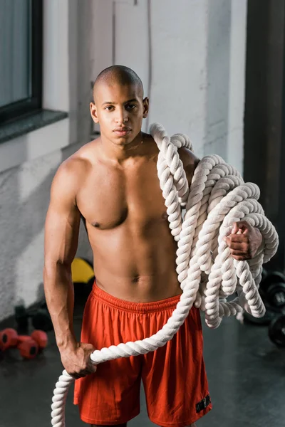 Muscular african american athlete with battle rope at gym — Stock Photo