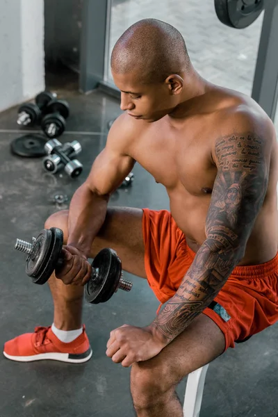 Vista de ángulo alto de atleta afroamericano haciendo ejercicio con mancuerna en el gimnasio - foto de stock