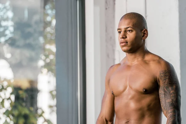 Retrato de un deportista afroamericano musculoso sin camisa en el gimnasio - foto de stock