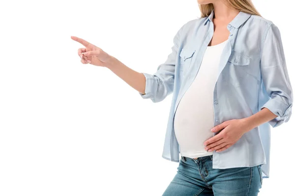 Обрезанный снимок беременной женщины, указывающей на пустое место, изолированное на белом — стоковое фото