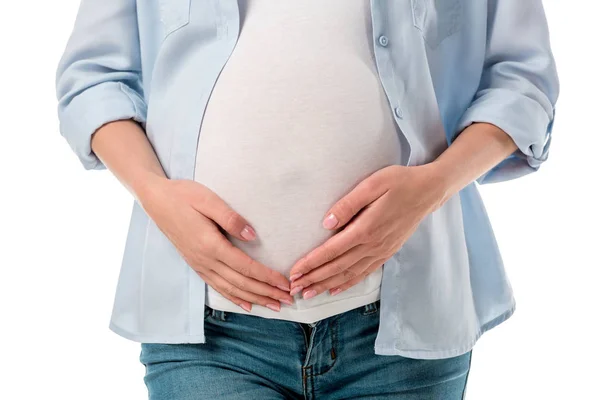 Schnappschuss einer schwangeren Frau in Jeans und Hemd, die den Bauch hält und die Hände isoliert auf weiß hält — Stockfoto