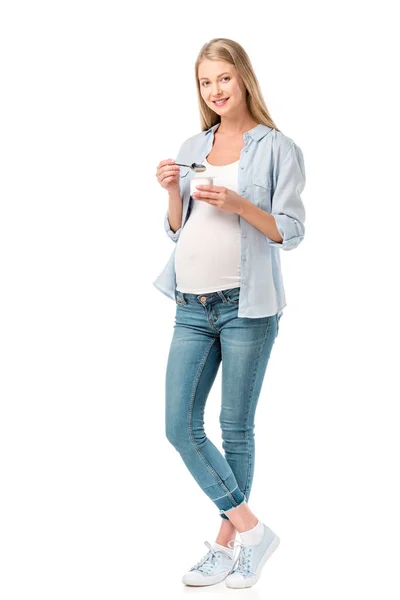 Bela mulher grávida sorrindo segurando iogurte isolado no branco — Fotografia de Stock