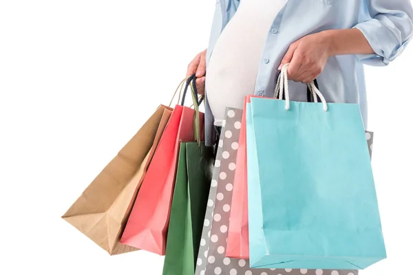 Vista recortada de la mujer embarazada con bolsas de compras aisladas en blanco - foto de stock