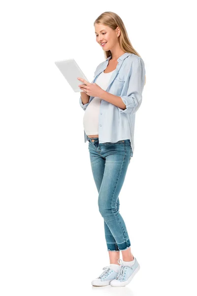 Приваблива вагітна жінка за допомогою цифрового планшета ізольована на білому — стокове фото