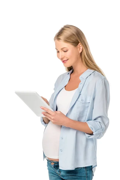 Smiling blonde pregnant woman using digital tablet isolated on white — Stock Photo