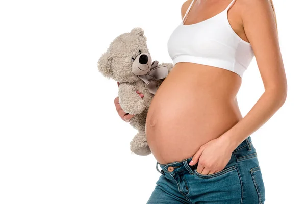 Cropped view of pregnant girl in white bra holding teddy bear isolated on white — Stock Photo