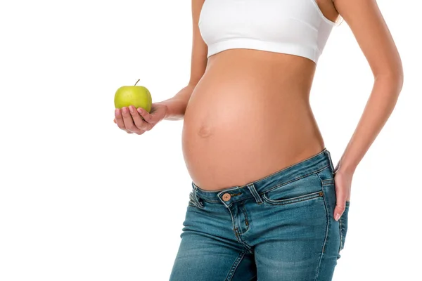 Abgeschnittene Ansicht einer schwangeren Frau mit grünem, frischem Apfel auf weißem Hintergrund — Stockfoto