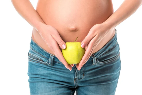 Обрезанный вид беременной женщины, держащей свежее здоровое яблоко рядом с животом изолированы на белом — стоковое фото