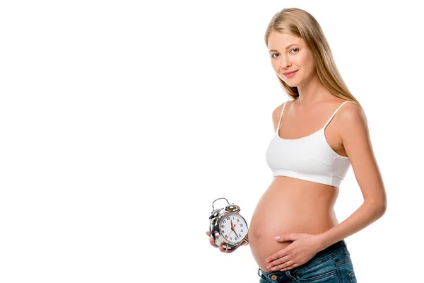 Blonde pregnant woman holding alarm clock isolated on white — Stock Photo