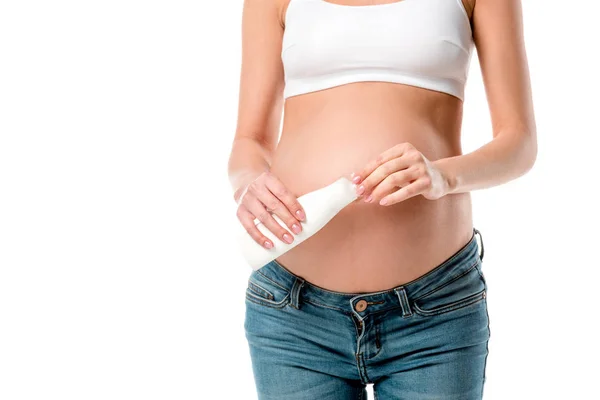 Vista ritagliata della donna incinta in possesso di bottiglia di lozione cosmetica isolata su bianco — Foto stock