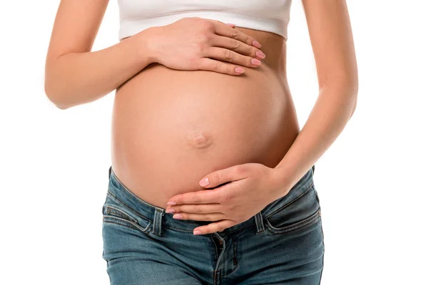 Abgeschnittene Ansicht einer schwangeren Frau, die ihren Bauch isoliert auf Weiß berührt — Stockfoto