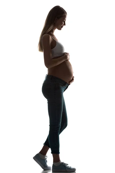 Силуэт беременной женщины, прикасающейся к животу изолированной на белом — стоковое фото