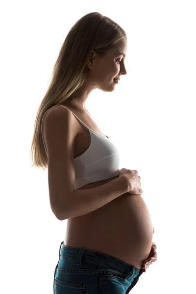 Силуэт беременной женщины, прикасающейся к животу изолированной на белом — стоковое фото