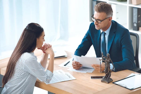 Vista ad alto angolo di avvocato e cliente che si guardano mentre discutono del contratto in carica — Foto stock