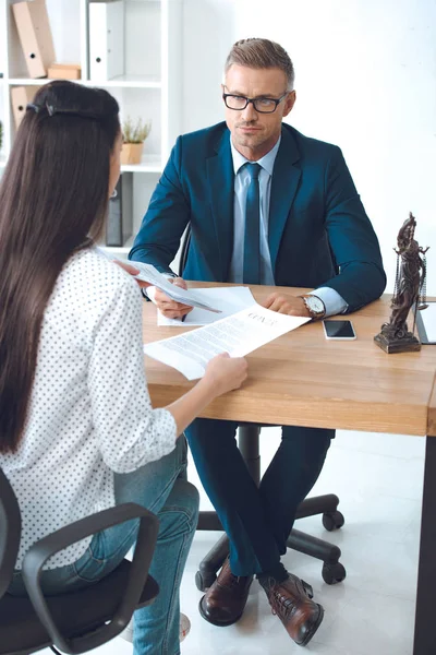 Lawyer and client looking at each other while working with contract in office — Stock Photo