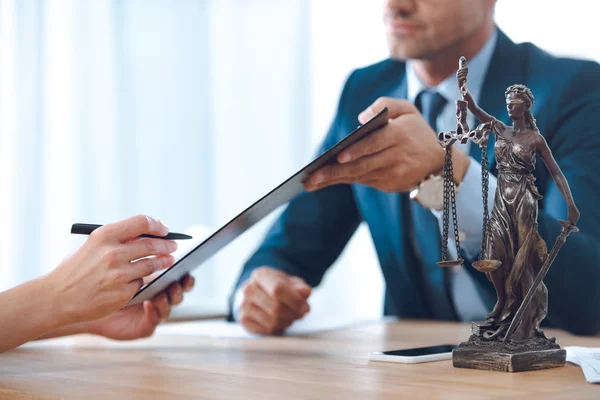 Recortado disparo de abogado portapapeles y documento de firma del cliente - foto de stock