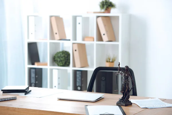 Estátua de justiça senhora, papéis e laptop na mesa no escritório — Fotografia de Stock