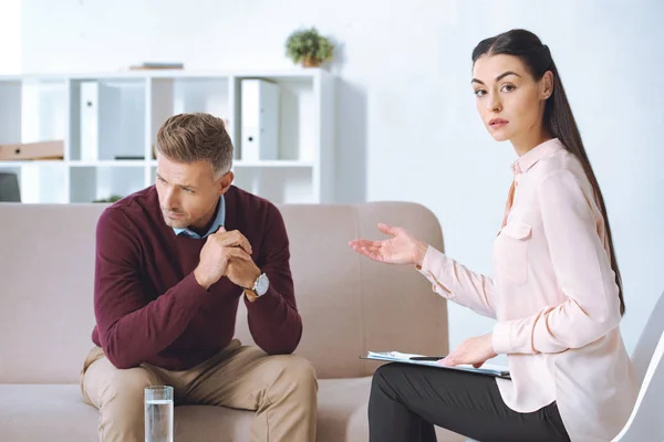 Hombre y mujer psicólogo teniendo sesión de terapia - foto de stock