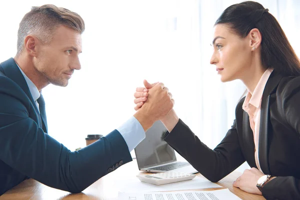 Seitenansicht von Geschäftsleuten beim Armdrücken am Arbeitsplatz im Büro — Stockfoto