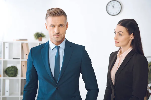 Portrait of businesswoman looking at confident colleague in office — Stock Photo