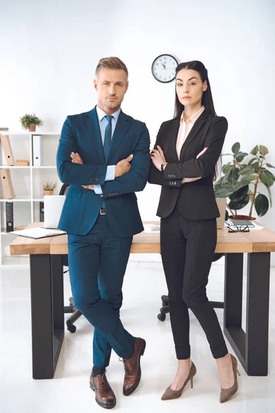 Empresarios con los brazos cruzados en el lugar de trabajo en la oficina - foto de stock