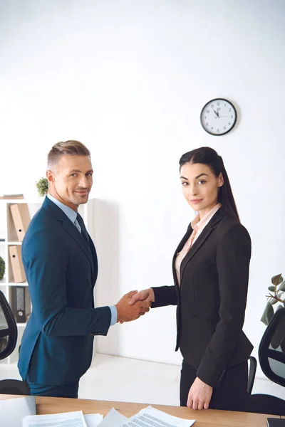 Visão lateral de colegas de negócios apertando as mãos no local de trabalho no escritório — Fotografia de Stock