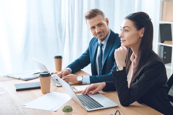 Side view of businesspeople working at workplace with laptop in office — Stock Photo