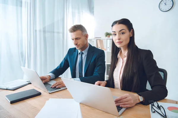 Businesspeople working at workplace with laptop in office — Stock Photo