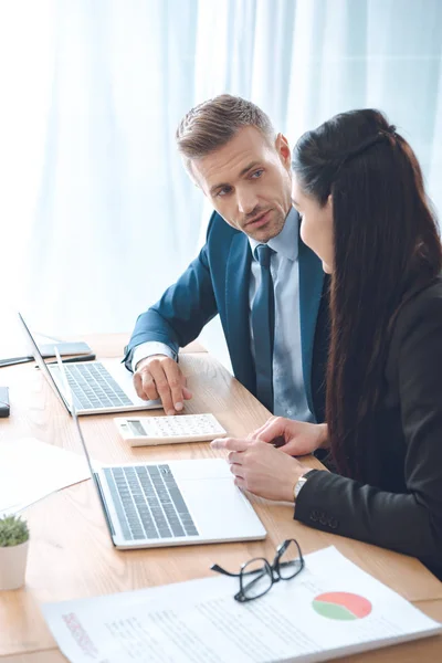 Vista laterale di uomini d'affari che lavorano sul posto di lavoro con laptop in ufficio — Foto stock