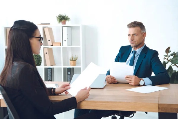 Partner commerciali con documenti che discutono il lavoro sul posto di lavoro in ufficio — Foto stock