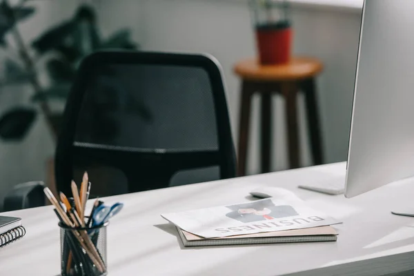 Jornal de negócios, computador e suprimentos em mesa no escritório de negócios — Fotografia de Stock