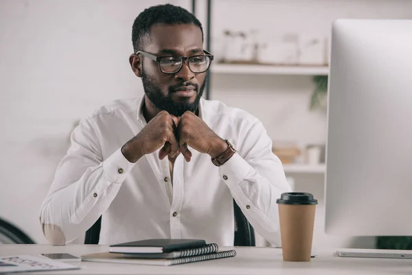 Красивый африканский американский бизнесмен смотрит на компьютер в офисе — стоковое фото