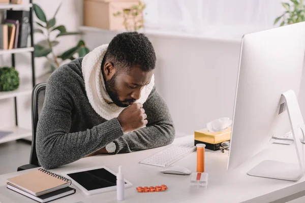 Empresário afro-americano doente tosse no local de trabalho com medicamentos — Fotografia de Stock