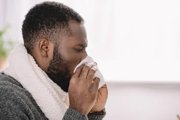 Malato afroamericano uomo con naso che cola tenendo tovagliolo — Foto stock