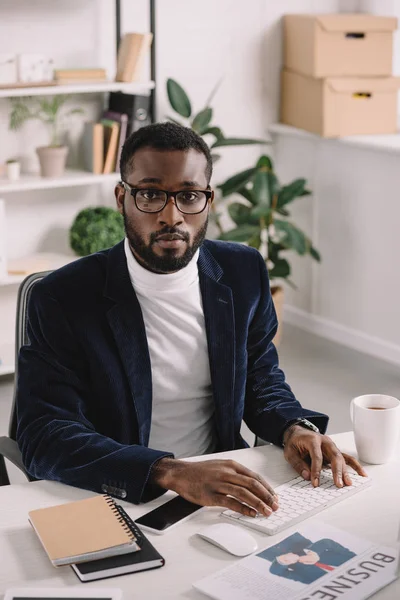 Stylischer afrikanisch-amerikanischer Geschäftsmann tippt im Büro auf Computertastatur — Stockfoto