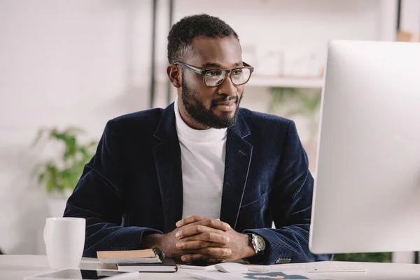 Succès homme d'affaires afro-américain travaillant avec l'ordinateur dans un bureau moderne — Photo de stock