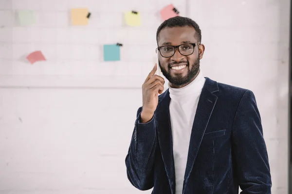 Uomo d'affari afro-americano sorridente in giacca di velluto che parla su smartphone — Stock Photo