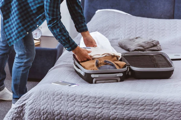 Обрезанный образ мужчины путешественника упаковки багажа в спальне на дому — стоковое фото