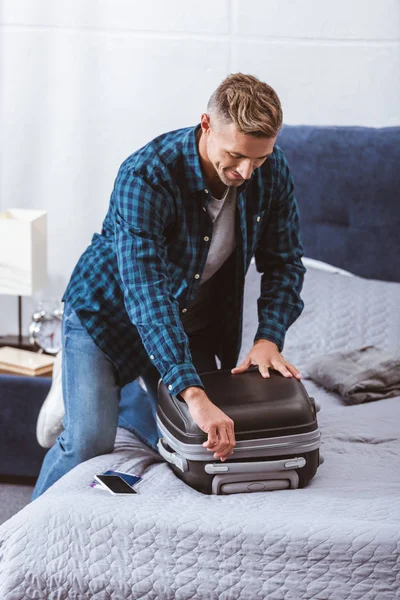 Heureux adulte emballage sac de voyage dans la chambre à coucher à la maison — Photo de stock