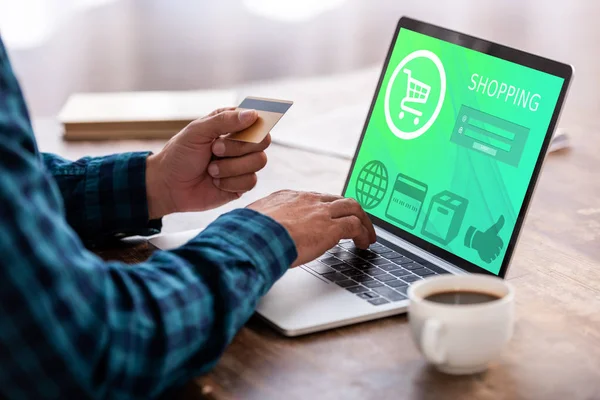 Cropped shot of man holding credit card and using laptop with shopping online website — Stock Photo