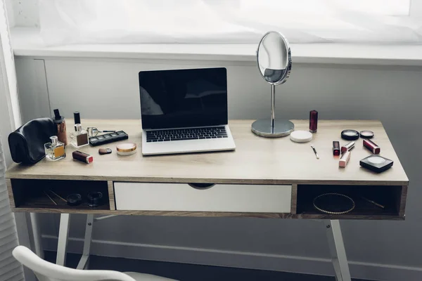 Plan rapproché du lieu de travail moderne avec ordinateur portable et fournitures de maquillage à la maison — Photo de stock