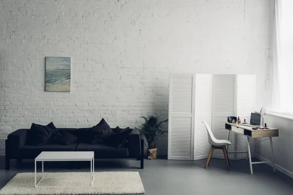 Intérieur du salon avec canapé et lieu de travail avec ordinateur portable — Photo de stock